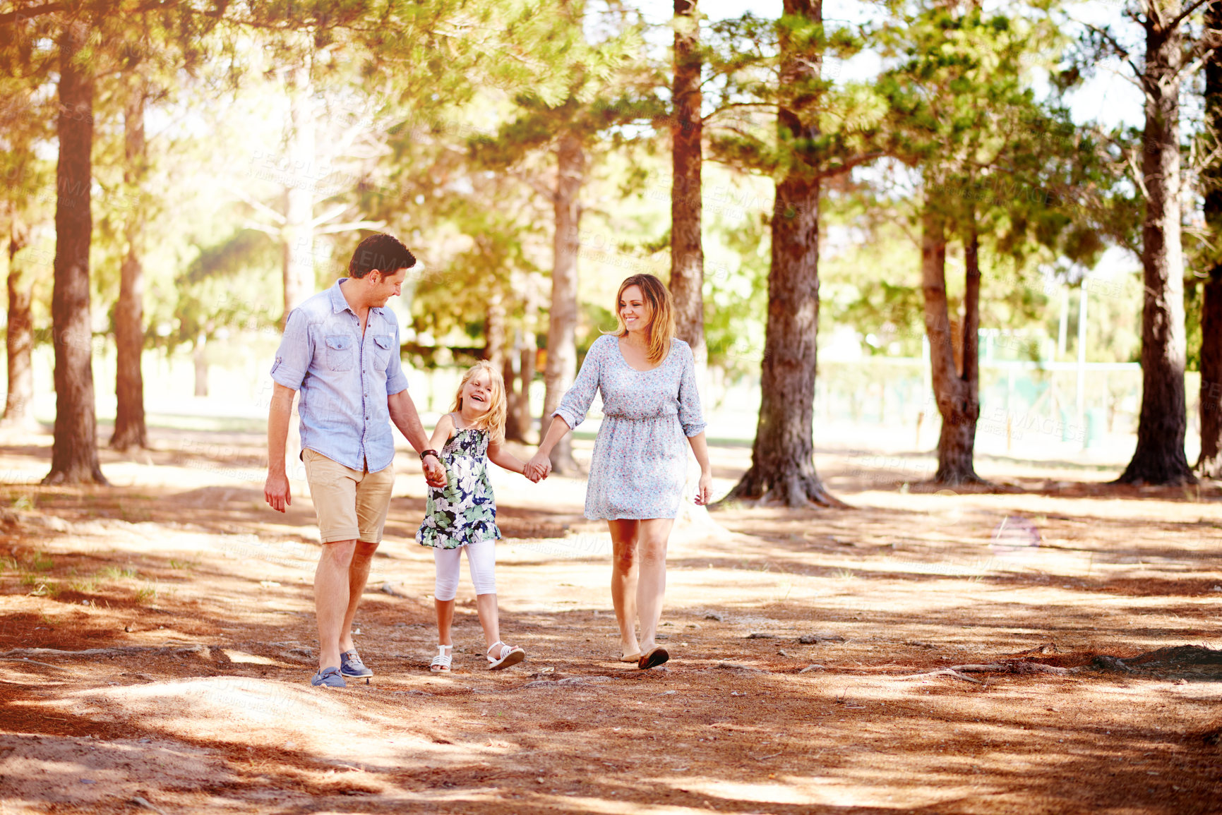 Buy stock photo Parents, child walking and holding hands at park for holiday, family vacation and laugh together. Mother, father and funny kid in nature for happiness, support and travel with girl on journey