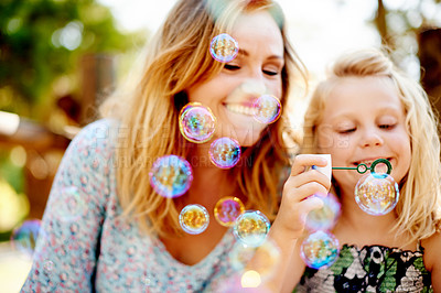 Buy stock photo Mother, child and blowing bubbles outdoor for sensory play, creative imagination or bonding. Family fun, mom and girl kid with soap toy in nature for learning activity, childhood development or bokeh