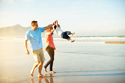 Buy stock photo Swing, happy and parents with child at beach for playing, bonding and relax outdoor on holiday. Family, travel and playful dad, mom and kid by ocean for adventure, vacation and weekend in nature
