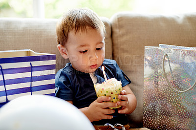 Buy stock photo Kid, toddler and candle on cupcake for birthday party, celebration and wish on special occasion. Child, blowing and cake with presents for event, family tradition and memories for milestone at house