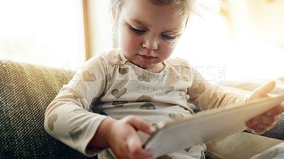 Buy stock photo Child, digital and online on couch with tablet, learning and playing in living room. Toddler, growth and development in home with technology, internet streaming and educational app in house.