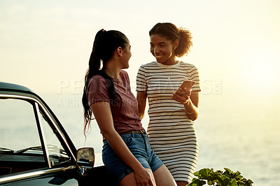 Buy stock photo Shot of two young women enjoying a road trip