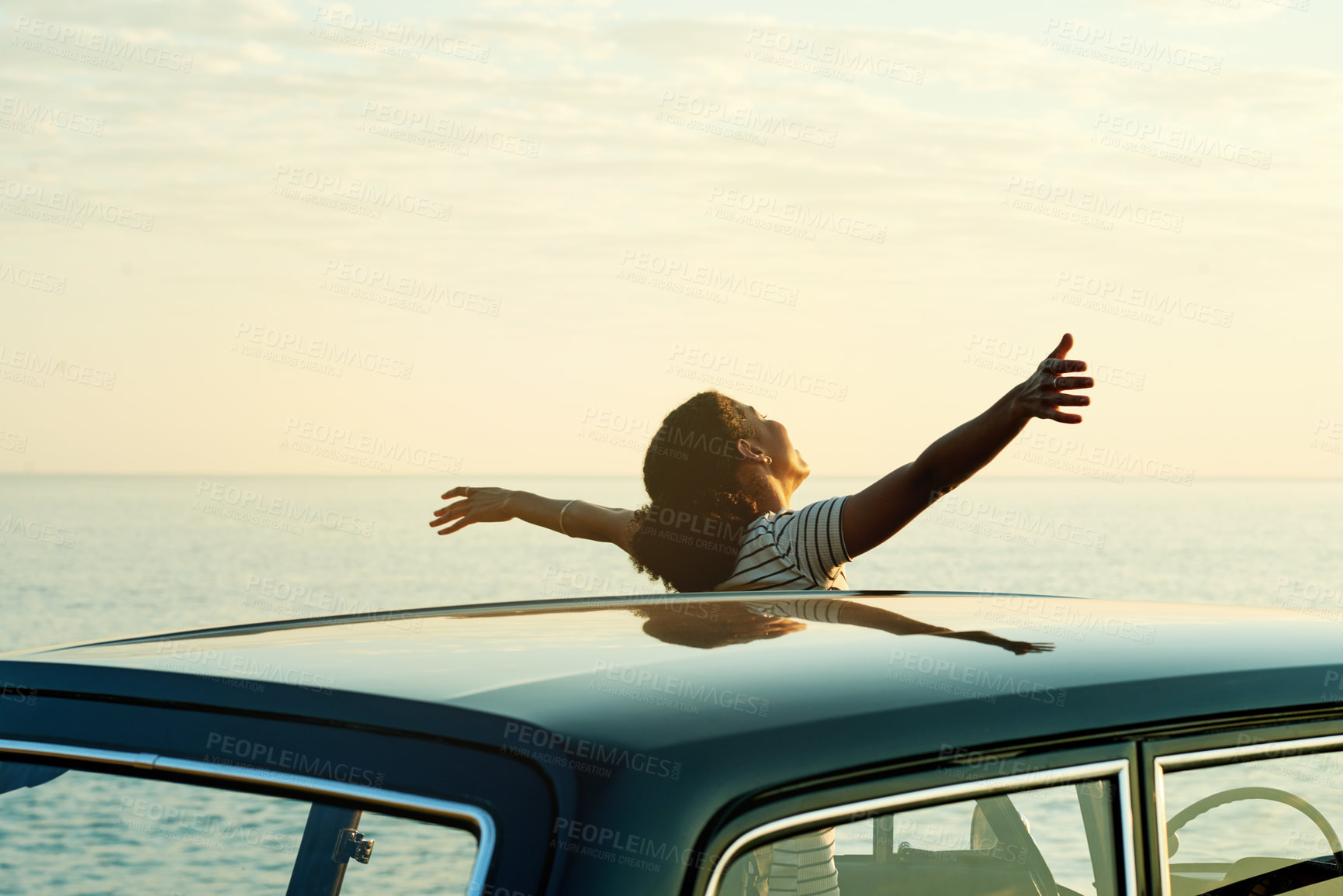 Buy stock photo Shot of a happy young woman enjoying a road trip