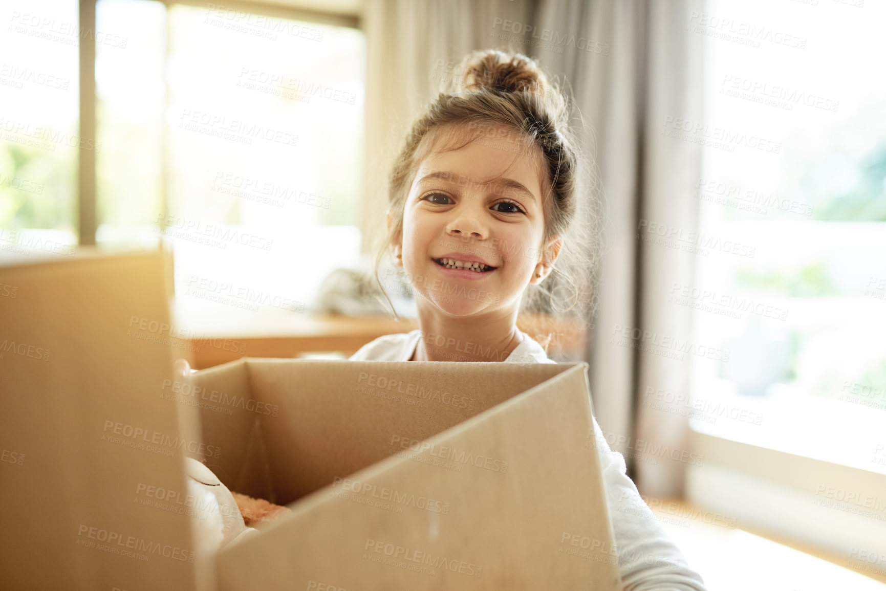 Buy stock photo Portrait, real estate and happy kid with box in new house, unboxing or pack for relocation to dream property. Face, moving or girl child with cardboard for donation, storage or carry toys for charity