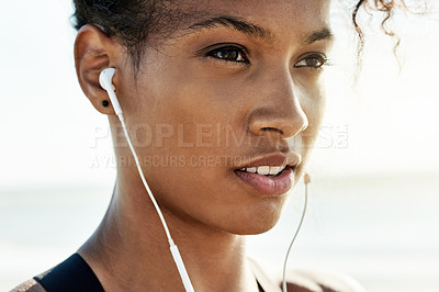 Buy stock photo Fitness, thinking and woman outdoor with earphones, health and playlist at beach. Wellness, exercise and African athlete in nature with music, face and streaming motivational podcast on break.