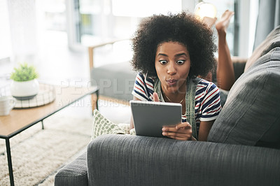 Buy stock photo Black woman, tablet and shock on sofa, surprise and notification with alert, gossip or chat in home. African girl, wow and tech on couch, laying and app with announcement on social media at apartment