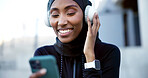 Music, fitness and muslim woman with phone in city, listen to radio or audio break with smile. Hijab, happy runner and black person with mobile, headphones and streaming playlist with podcast outdoor