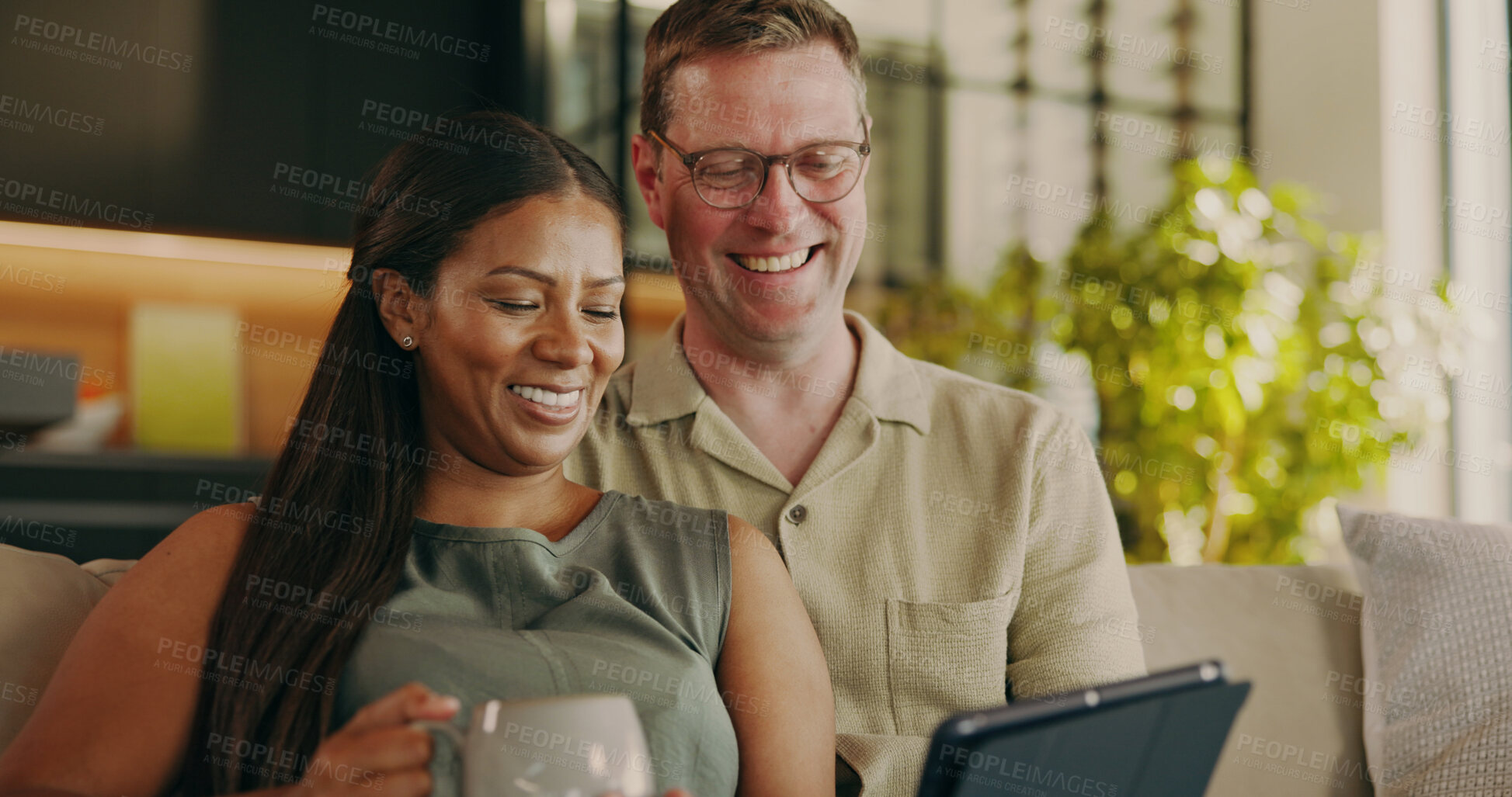 Buy stock photo Relax, smile and tablet with interracial couple on sofa for streaming service, bonding and love. Film subscription, connection and happy with man and woman in living room in home for media app