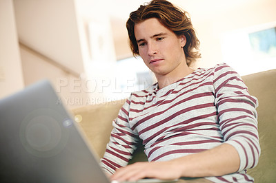 Buy stock photo Laptop, typing and man on sofa for application, reading and university scholarship email in home. Tech, research and male student in living room for college admission test, exam or study assignment