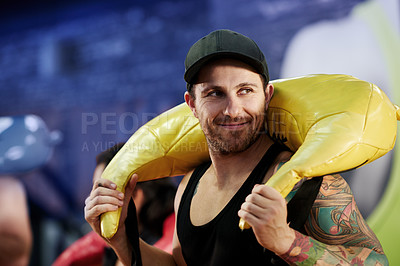 Buy stock photo Gym, carry or happy man with sand bag for training, shoulder workout or core strength. Athlete, lifting or person in club studio with weight equipment for fitness cardio, body health and exercise