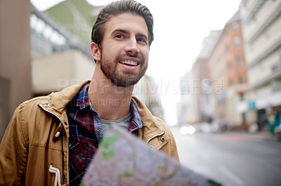 Buy stock photo Man, smile and map in city for travel, location search and sightseeing on urban vacation. Tourist, looking and downtown with paper chart for tour, navigation and find landmark on holiday in Portugal