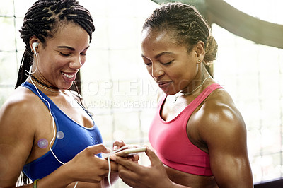 Buy stock photo Phone, friends and women in gym with music for exercise, workout app and training together in morning. Happy, fitness and African people on mobile for social media, internet and online with earphones