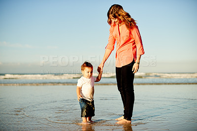 Buy stock photo Holding hands, beach and mother with child in ocean for bonding, care and connection on holiday. Happy, support and mom walking with boy kid in sea water for fun together on tropical vacation.