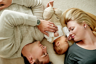 Buy stock photo Above, parents and relax with baby in home for bonding together, security or relationship. Happy family, people and newborn with affection on floor for connection, early childhood development or love