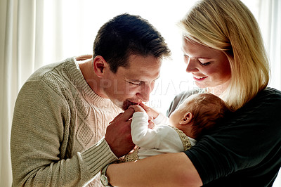 Buy stock photo Mom, dad and baby in home for bonding, loving relationship and kiss for affection together. Family, parenting and embrace with mother, father and newborn for comforting, trust and security in house