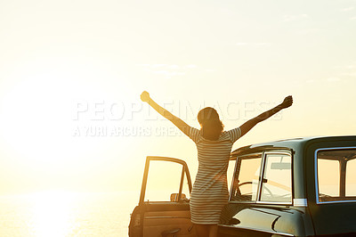 Buy stock photo Shot of a happy young woman enjoying a road trip