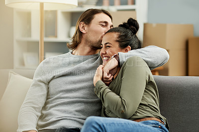 Buy stock photo New home, boxes and couple kiss on sofa to relax for moving, relocation or real estate purchase. Homeowners, bonding and man with woman with embrace, love and support for property, mortgage or house