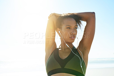 Buy stock photo Earphones, fitness and stretching with woman on beach for start of cardio training or workout. Arms, music and thinking with African athlete outdoor on space for exercise preparation or warm up