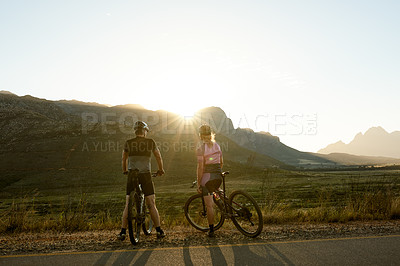 Buy stock photo Sunrise, cycling and back of people on bicycle for sports, outdoor exercise and workout. Morning, flare and man with woman on bike in countryside for travel, wellness and fitness in nature with view
