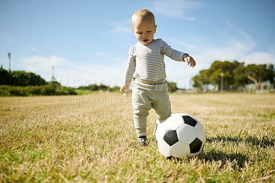 Buy stock photo Outdoor, baby and soccer ball on a grass field with mobility development and growth in nature. Child, park and kicking toddler with sport equipment with a kids toy in the summer sun ready to learn 