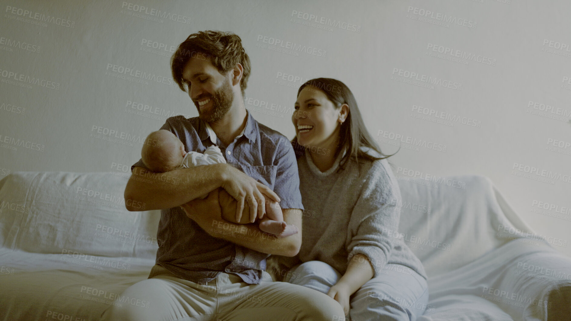 Buy stock photo Smile, parents and baby on a sofa in the living room of their home together for love, care or bonding. Family, relax or happy mother and father holding their cute newborn infant chid in a house