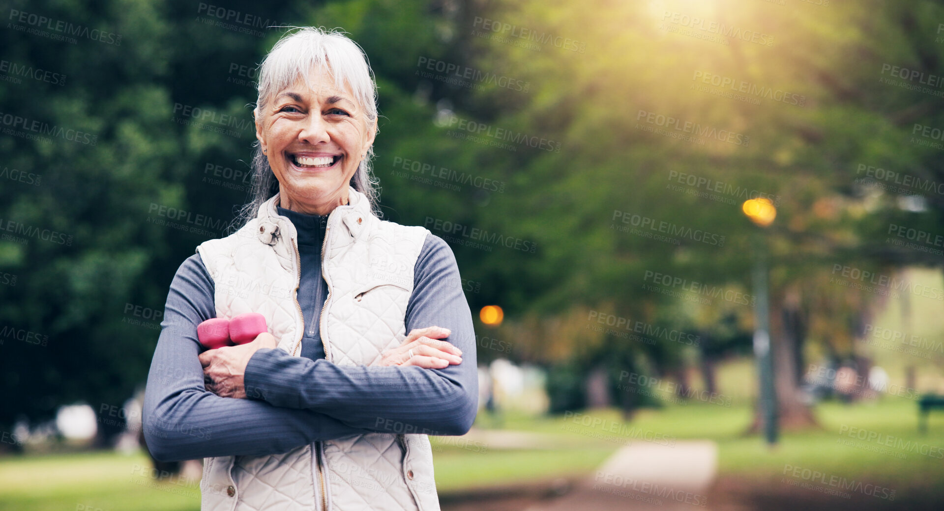 Buy stock photo Portrait, old woman and dumbbells in nature for fitness, exercise and smile for healthy lifestyle. Happy, senior person and arms crossed at park with equipment, workout and stress relief for wellness