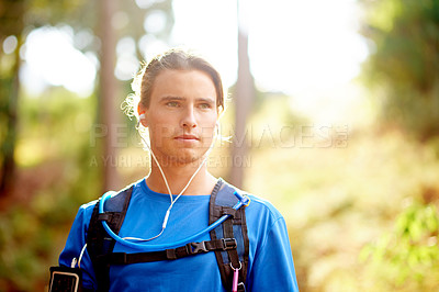 Buy stock photo Hiking, music and thinking with man in forest for exercise, fitness or sports routine outdoor. Earphones, journey and vision with confident athlete in mountains for hobby, marathon or recreation