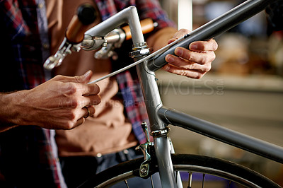 Buy stock photo Hands, repairs and man with tools for fixing bicycle in garage for maintenance on wheels, chain or frame. Small business, service and mechanic with tightening mechanical part on bike at workshop.