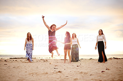 Buy stock photo Freedom, girl and jump with friends at beach, people and happy with vacation for bonding. Fun, energy and excited female person with group at sunset, adventure or travel for summer coastal reunion