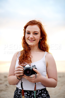 Buy stock photo Portrait, photographer and happy woman at beach with camera for holiday, vacation and memory. Smile, photography and girl at seashore for picture, summer trip or tourist travel at sunset in Greece