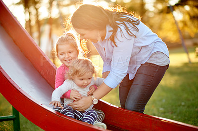 Buy stock photo Playground, happy and mom with children on slide for outdoor adventure, playing and having fun together. Family, summer and mother with kids at park for bonding, connection and relationship in nature