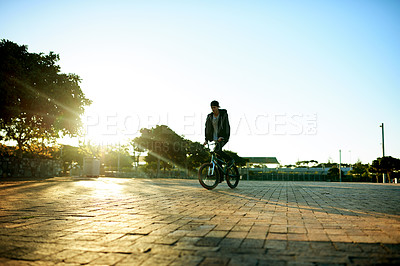 Buy stock photo Urban, space and man on bicycle for cycling, training or travel in city street to relax. Male person, blue sky or stunt biker in town at sunrise for holiday, vacation or outdoor activity for wellness