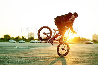 Buy stock photo Man, bike and stunt in city at sunset with challenge, talent or action outdoor for extreme sports. Skill, trick or risk with person, athlete or rider for performance, bicycle and energy in urban park