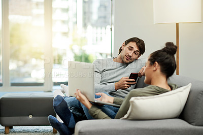 Buy stock photo Conversation, laptop and relax with couple on sofa in living room of home together for break. Computer, phone and sharing with people talking in apartment for connectivity, browsing or social media