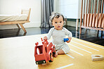 Toy truck, baby play and portrait in home, having fun and relaxing in house nursery. Development, childhood and playful and cute child, infant or newborn playing with block, red car and learning.