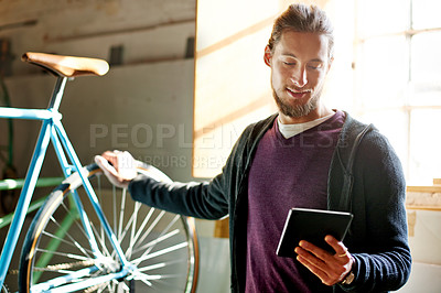 Buy stock photo Man, tablet and bike repair at workshop with smile for schedule, invoice and research for maintenance. Person, bicycle and tech with application, inspection and restoration services at small business
