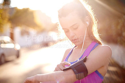 Buy stock photo Girl, earphones and phone for fitness in city for getting ready, listening to music and wellness app. Teenager, mobile and streaming podcast for morning routine, start timer and website for exercise