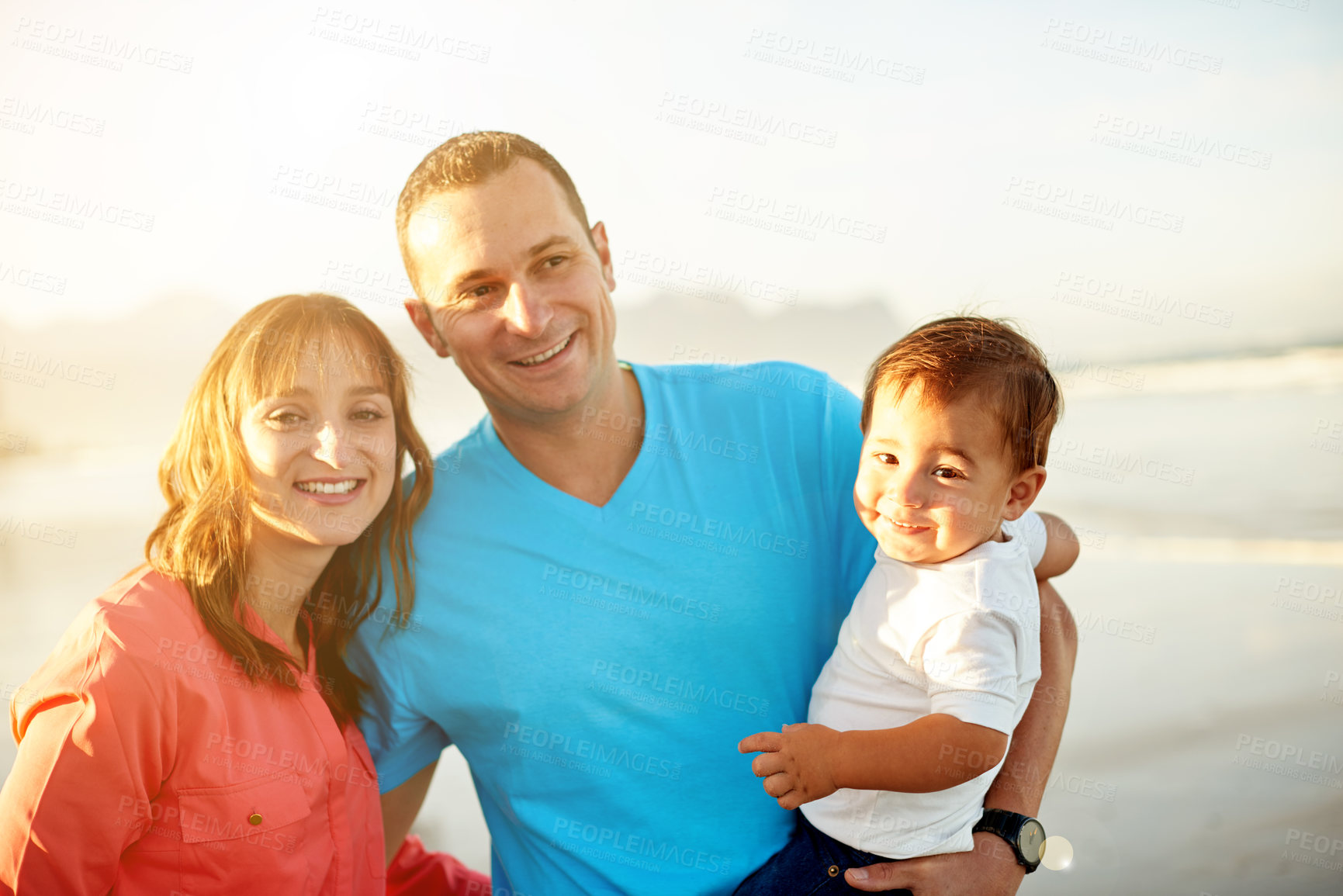 Buy stock photo Happy family, hug or beach with baby for holiday, weekend getaway or outdoor bonding together. Dad, mom or child with smile on ocean coast or sea for summer vacation, sunshine or childhood in nature