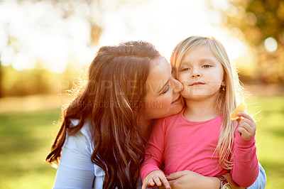 Buy stock photo Love, mother and kiss child at park for safety, security and eating fruit on vacation with bokeh. Nature, mom and hug girl with parent for support, care and hungry kid with orange on family holiday