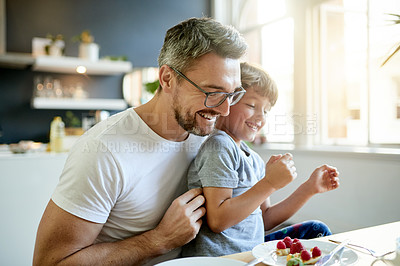 Buy stock photo Breakfast, happy and father with kid in kitchen in home with bonding, laughing and wellness. Smile, health and dad with boy child for eating healthy morning meal together with connection in house.