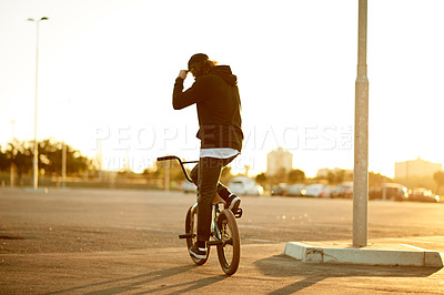 Buy stock photo Urban, back view and man on bicycle for cycling, training skill or travel in city to practice. Cool, male person or stunt biker in town at sunrise for holiday, vacation or outdoor activity for biking