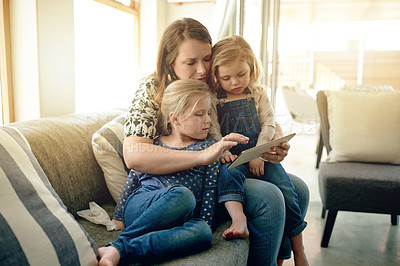 Buy stock photo Mom, children and relax on sofa with tablet, search and choice for movie with bonding in living room. People, mother and daughter kids with tech, app or embrace on couch for film at family house