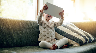 Buy stock photo Smile, toddler and online on couch with tablet, digital learning and playing in living room. Happy, child and video games in home with technology, internet streaming and educational app in house.