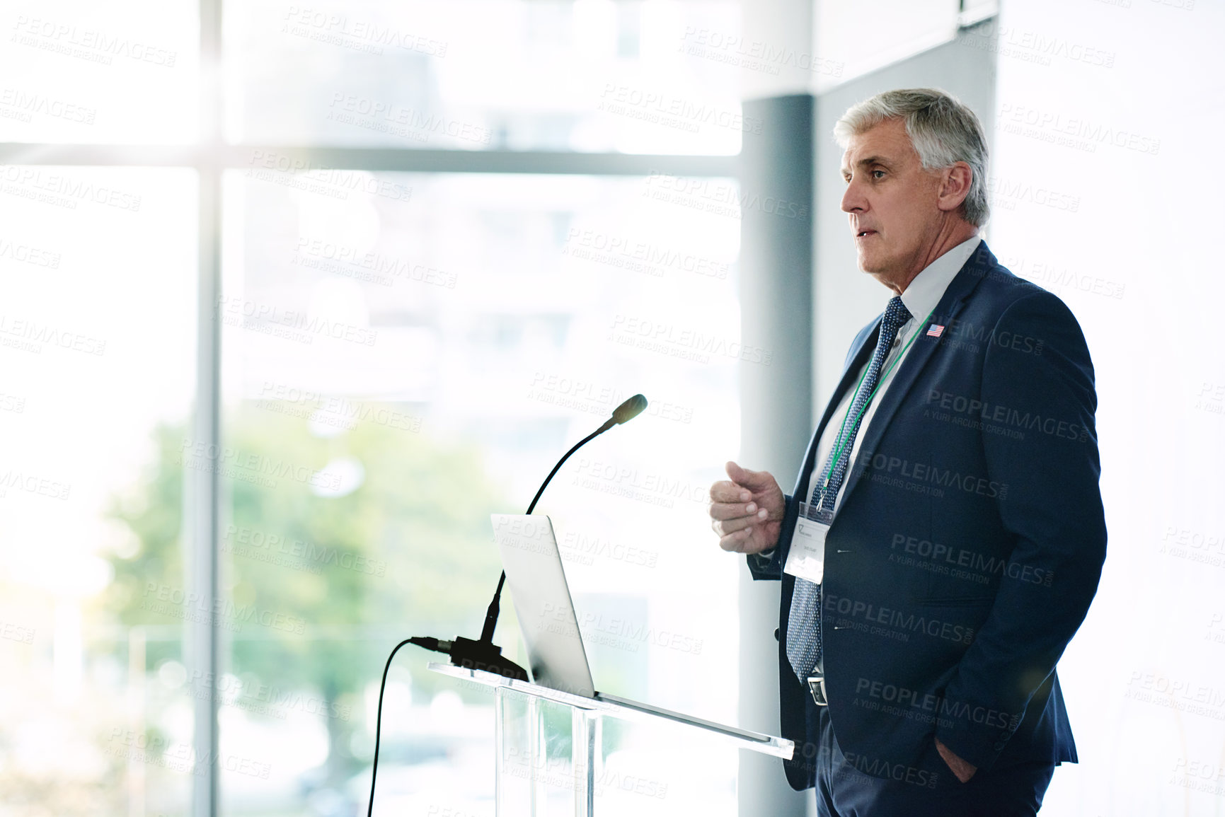 Buy stock photo Presentation, business or mature man in office at podium, communication or strategy in training workshop. Presenter, vision or CEO in workplace with laptop, coaching or feedback in workforce learning