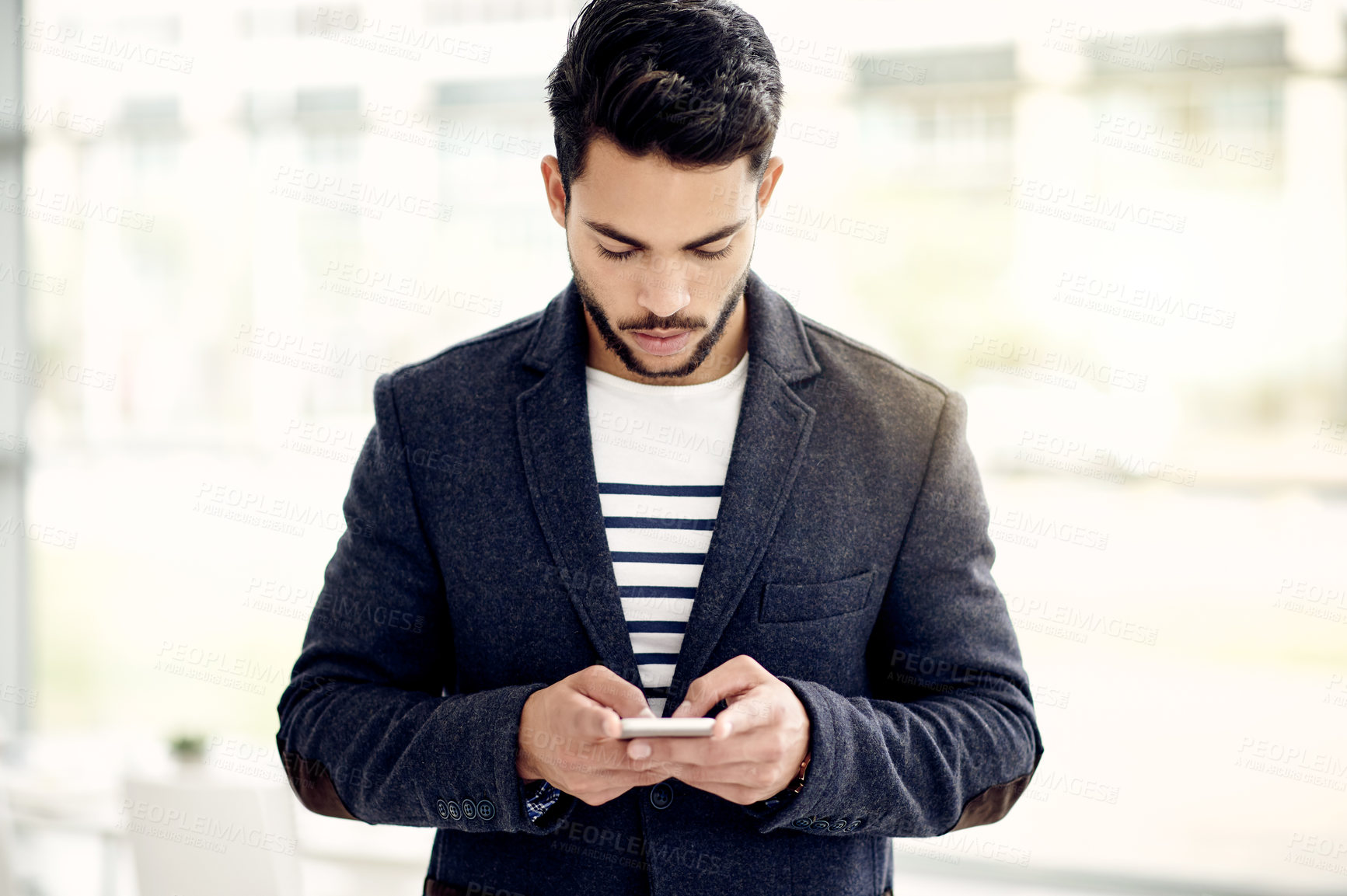 Buy stock photo Man, phone and texting at startup with app for contact, notification or networking at media company. Person, smartphone and scroll at office with proposal, deal and web chat at creative agency