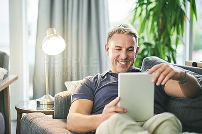 Buy stock photo Home, typing and man on couch, tablet and relax with social media, ebook and connection. Apartment, tech and happy person with app, online reading and communication with subscription for news report