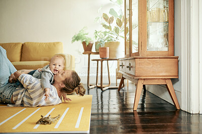 Buy stock photo Family, play and mama kiss baby in home for bonding, quality time and relax together on floor. Living room, love and happy mother with kid playing for child development, care and happiness on weekend