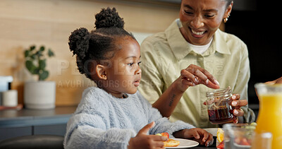 Buy stock photo Eating, kitchen and mom with child for breakfast, healthy meal and morning routine for wellness. Family, food and African girl with mother, juice and honey for vitamins, growth and help in home
