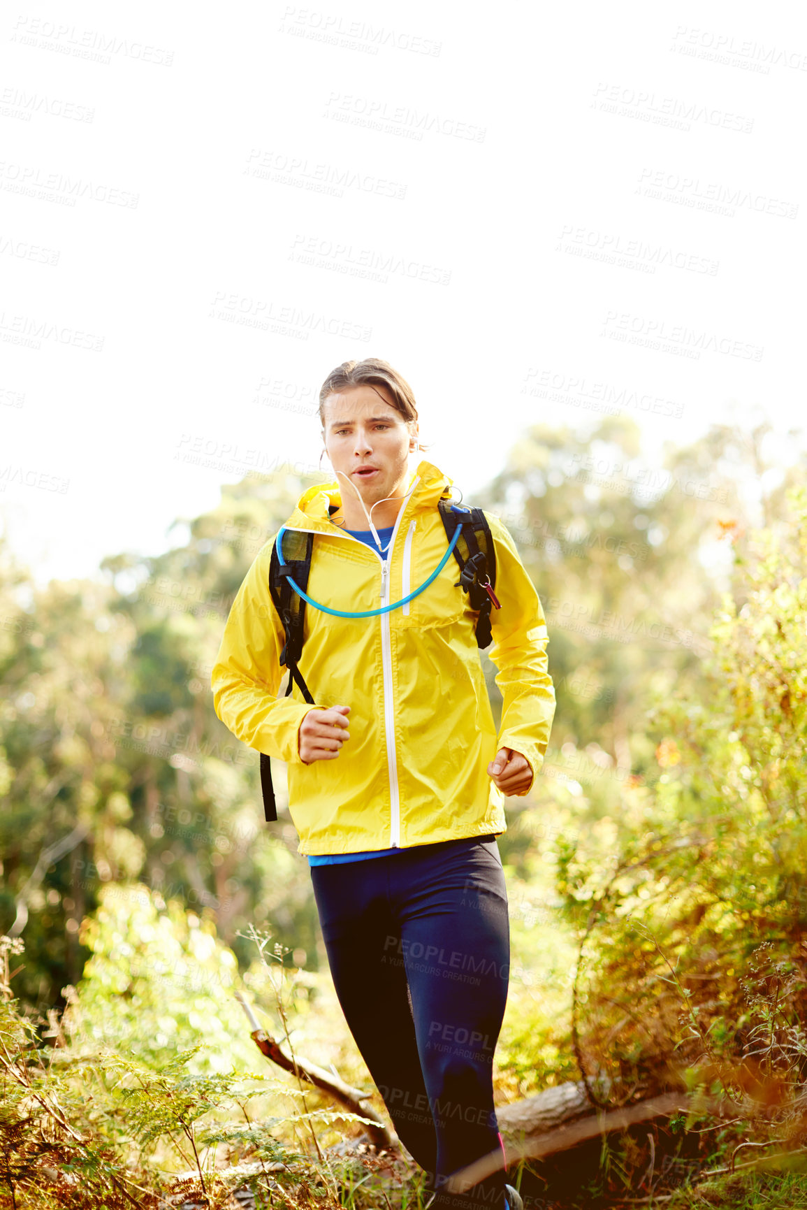 Buy stock photo Running, active and man with earphones, forest and listening to music for motivation, outdoor and speed. Nature, athlete and person with energy for sport, streaming or entertainment of radio in woods