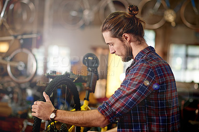Buy stock photo Small business, building or man with bike in workshop or store for fixing, maintenance or upgrade. Wheel alignment, warehouse or mechanic in garage for bicycle parts, mechanical engineering or repair